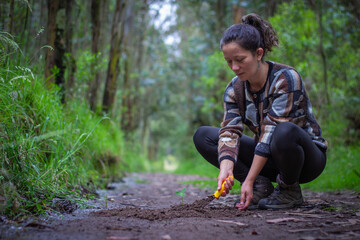 Woman planting a small tree in a forest. Environmental conservation, sustainability, and reforestation concept. Nature preservation and ecological awareness in action. Earth Day © GABRIEL