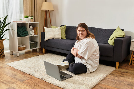 Young woman with Down syndrome enjoys a cozy moment at home, engaging with her laptop in comfort