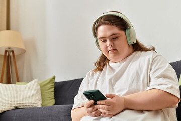 Young woman with Down syndrome enjoys music while relaxing at home in a cozy setting