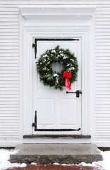 Photo of holiday wreath on an antique white door.