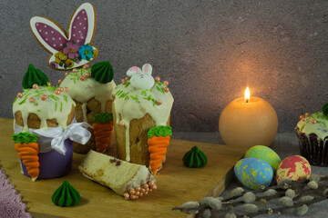 easter cake with colored icing and chocolate eggs. festive easter cake with icing on rustic wooden background. traditional easter cake with eggs and icing.