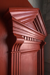 Restored door with carved cornice decor with triangular pediment and massive brackets. Rich color emphasizes architectural details © pavlobaliukh