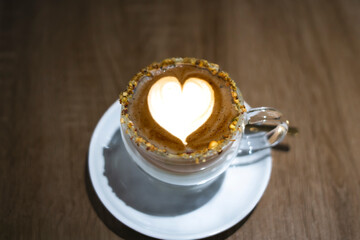 Pistachio latte art creating heart shape on coffee surface