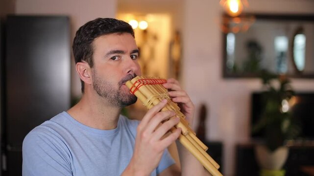Man playing a wooden pan flute 