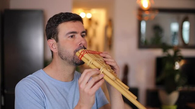 Man playing a wooden pan flute