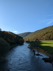 Blue clear sky landscape Ardennes, Belgium with river meadows and forest