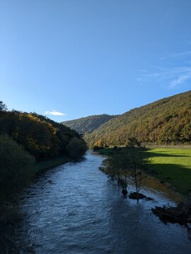 Blue clear sky landscape Ardennes, Belgium with river meadows and forest