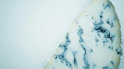Close-up of Blue Cheese Wedge with Distinctive Veining on Light Blue Background