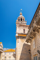 Fototapeta premium Korcula town in island of Korcula in Adriatic sea in Croatia, Europe. Architectural splendor: A weathered stone tower rises against a vibrant blue sky, showcasing detailed stonework.