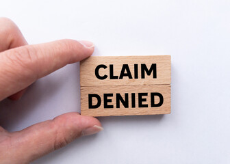 Claim denied message written on wooden blocks on white background. Conceptual claim denied symbol....