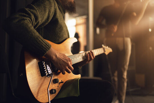 Guitarist play electric guitar, close up on hands. Music creativity, performance energy, indie rock atmosphere, teamwork.