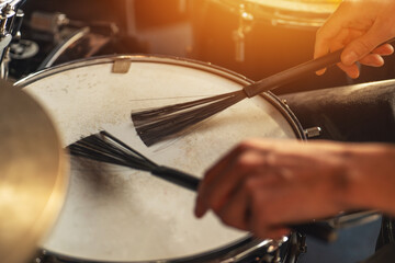 Naklejka premium Hands playing snare drum with jazz brushes, detailed percussion close-up, soft rhythm, acoustic music technique, jazz session, artistic expression.