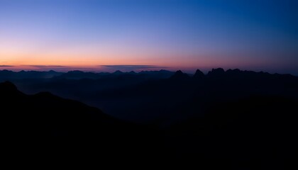 Fototapeta premium Mountain Range Silhouette at Dusk with Soft Sunrise Hues