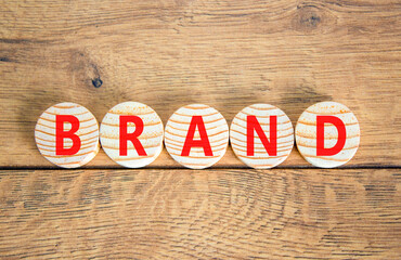 Fototapeta premium Brand symbol. Concept word Brand on beautiful wooden circles. Beautiful wooden table wooden background. Business brand concept. Copy space.