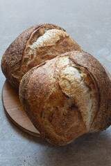 Fresh crusty sourdough bread with the addition of whole wheat flour on a gray background.s. Yeast-free bread Tartine, healthy food.