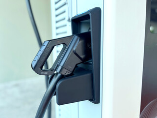 electric vehicle EV charging station with plugged in charging cables, Modern sustainable...