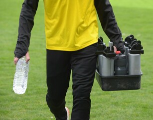 encadrement et ramassage des bouteilles d'eau sur le terrain au football	