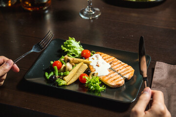 Grilled trout steak with vegetables on a plate
