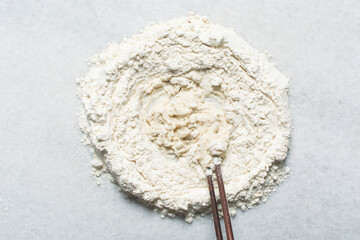 Overhead view of steamed bun dough being mixed on a granite countertop, top view of mantou dough being mixed, process of making steamed milk buns
