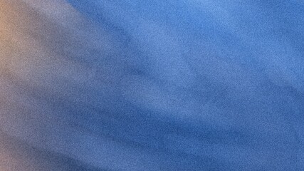 A blurry image showing a gradient of blue and peach colors with soft textures and diffused lighting...