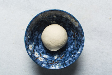 Overhead view of steamed bun dough rising, top view of mantou dough in a bowl, process of making steamed milk buns