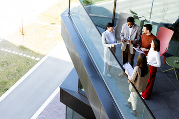Group of professionals collaborating on project details in modern office space during sunny day