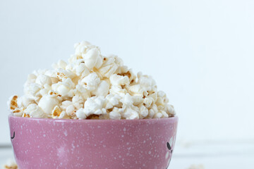 Homemade popcorn in a bowl with white background. Close-up. Copy space.