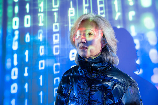 Elderly asian woman exploring virtual reality metaverse