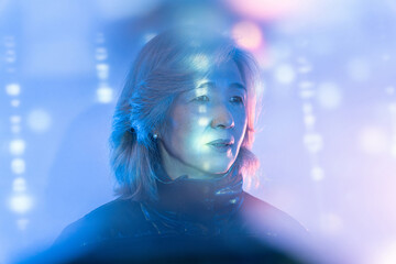 Elderly asian woman exploring the metaverse interface