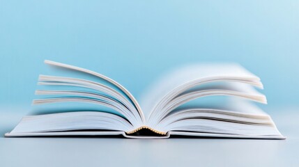 Fototapeta premium close-up of open book with pages curling slightly at edges set against softly blurred background to highlight texture