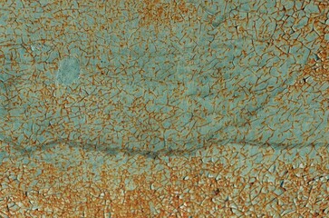 Textured surface with peeling paint exhibiting shades of turquoise and rust in an abstract display...