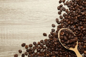 Coffee beans in a spoon on wooden background