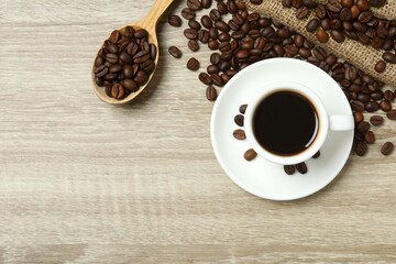 Cup of coffee with coffee beans on wooden background