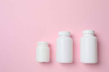 White bottles on color background, top view