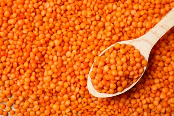 Red lentils in wooden spoon