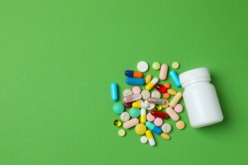 Various pills with white bottle on color background, top view
