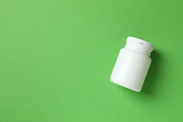 White bottle on color background, top view