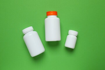 White bottles on color background, top view