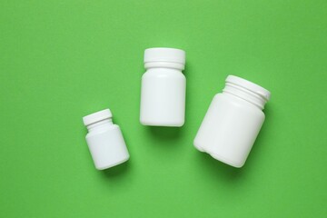 White bottles on color background, top view