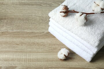 Stack of white towels and cotton flowers on the table