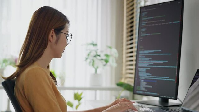 A confident woman codes diligently in a corporate atmosphere, exemplifying success and commitment to technology.