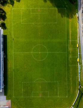 Aerial view of football field with green grass and sunlight
