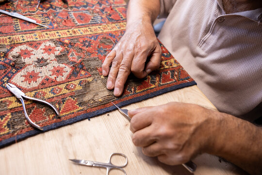 Iranian carpet restorer at work in Salzburg workshop