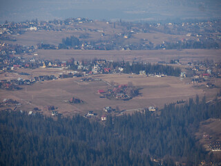 Distant Aerial View of Mountain Countryside with Rural Settlements Scattered Across Rolling Hills...
