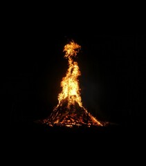 Saint John s Day celebration in Lithuania. A large bonfire burns brightly against a dark night sky....