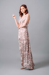 Summer frill maxi sundress in floral design with plunge neckline. Beautiful happy smiling redhead...