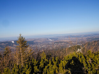 Panoramic Mountain Vista Overlooking Vast Valley and Distant City with Winding River on Sunny Day