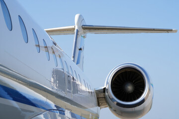 Commercial airplane jet engine and wing close-up against blue sky