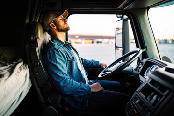 Young caucasian male truck driver relaxing in cabin after long day of travel at truck stop