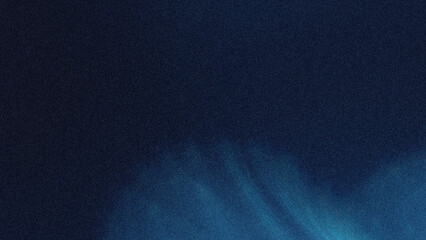 A blurry abstract image showing a dark blue background with a lighter blue area in the lower right corner